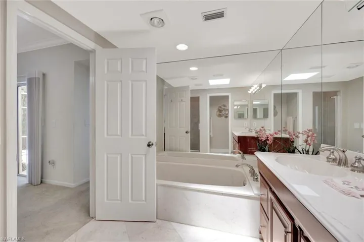 Bathroom with a garden tub, visible vents, a shower stall, vanity, and baseboards