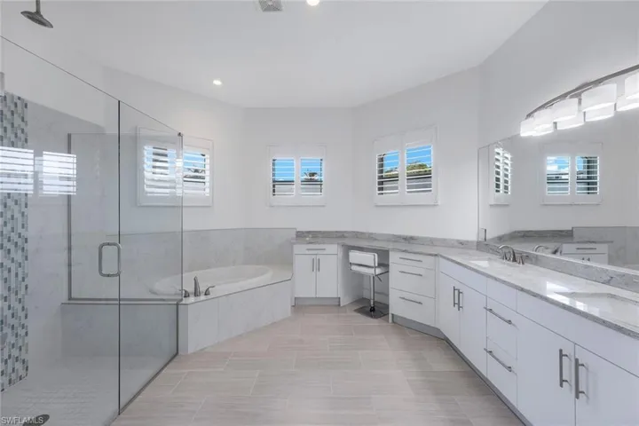 Master Bathroom featuring vanity with separate shower and tub