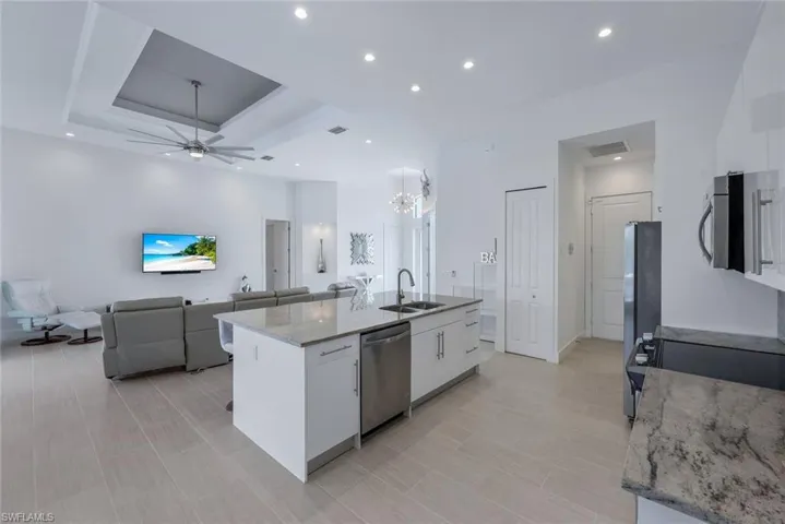 Kitchen featuring white cabinets, stainless steel appliances, decorative light fixtures