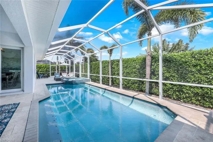 View of swimming pool featuring a lanai, a patio, and an in ground hot tub