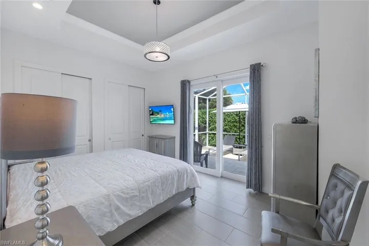 Bedroom featuring a raised ceiling and access to pool