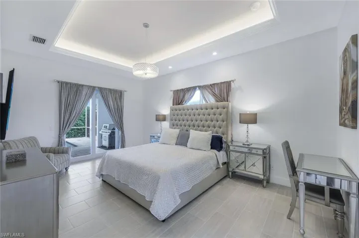 Master Bedroom with access to outside and a tray ceiling