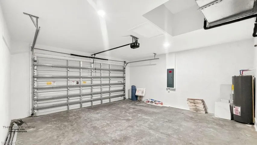 Spacious garage featuring a concrete floor, white painted walls, and an automatic garage door opener