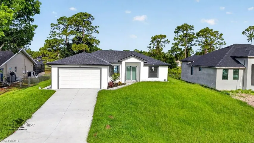 Contemporary single-story residence featuring a dark shingle roof and white exterior