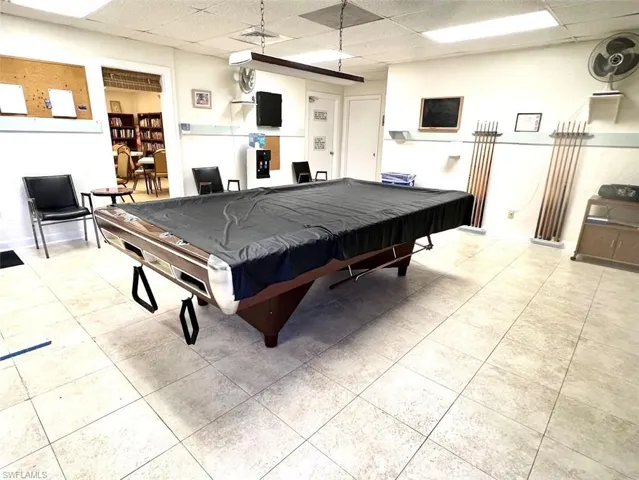 Recreation room with a paneled ceiling and pool tables