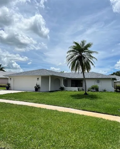 Ranch-style home with a garage and a front lawn