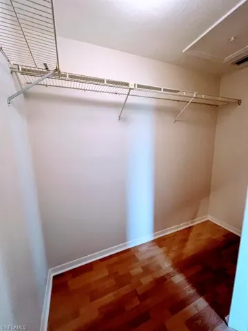 Master bedroom with large Walk in closet featuring hardwood / wood-style flooring