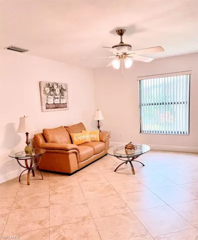 Living room with ceiling fan and light tile patterned floors