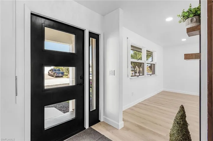 Entryway with light wood-style floors and recessed lighting