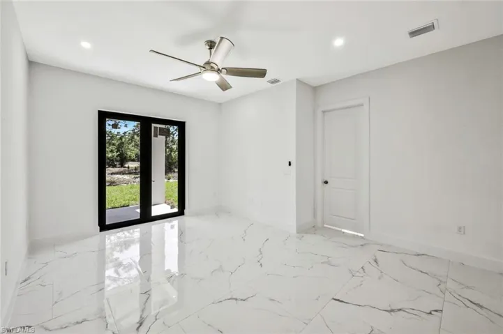 Spare room featuring french doors, a ceiling fan, light marble finish floors, and recessed lighting