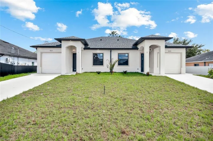 Prairie-style home featuring an attached garage, stucco siding, driveway, and roof with shingles