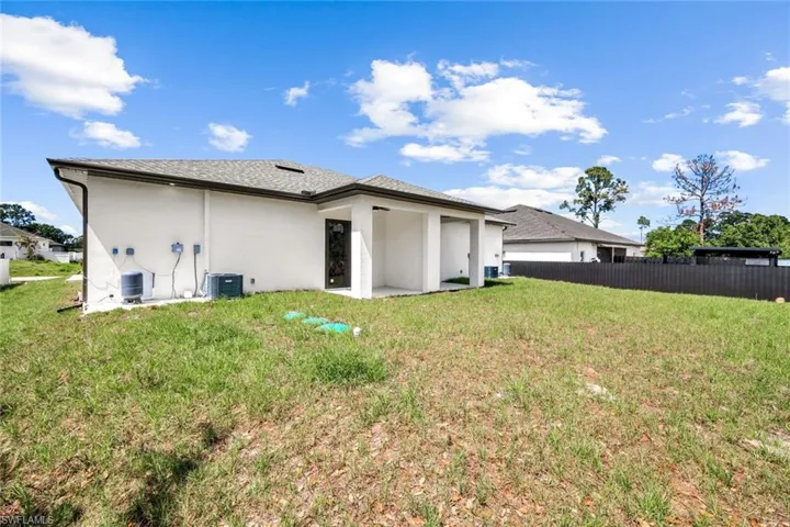 Back of property featuring stucco siding, a patio area, and a shingled roof
