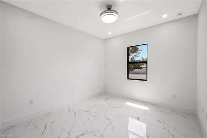 Unfurnished room with light marble finish flooring and recessed lighting