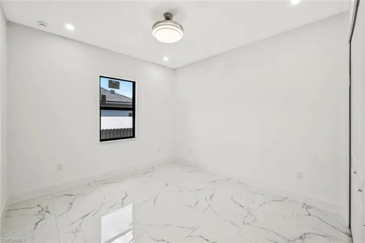 Empty room featuring light marble finish floors and recessed lighting