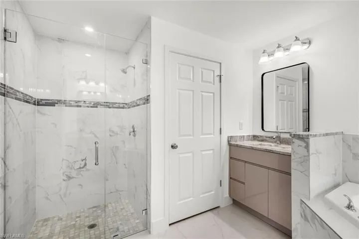Updated bathroom featuring a tiled walk-in shower, contemporary vanity, and clean modern finishes.