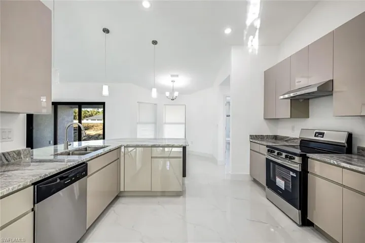Streamlined kitchen view showing ample counters, modern cabinetry, and an efficient layout with stainless range and hood.