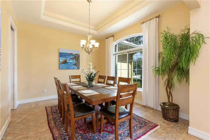 Dining room featuring a notable chandelier, a tray ceiling, and crown molding