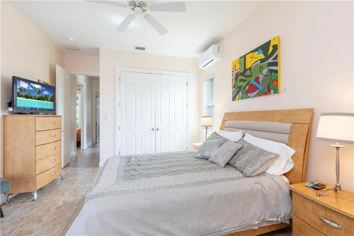 Bedroom featuring ceiling fan, a closet, and a wall mounted AC