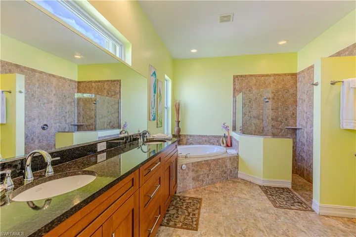 Bathroom featuring vanity and separate shower and tub