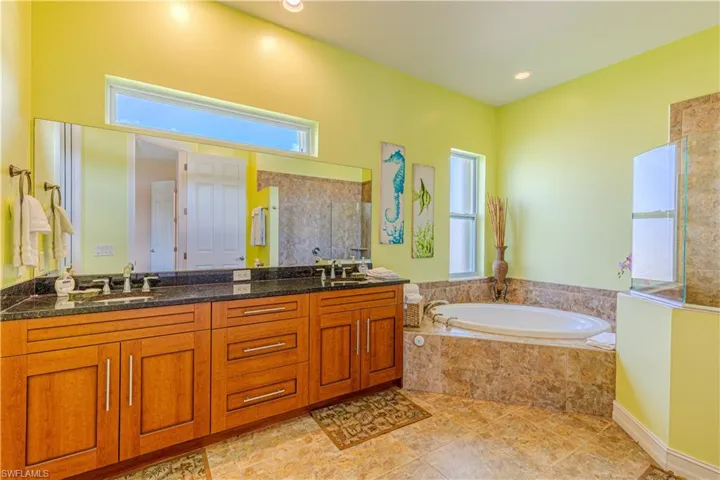 Bathroom with separate shower and tub, tile patterned floors, and vanity