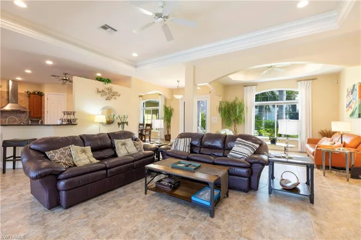 Tiled living room featuring crown molding and a raised ceiling