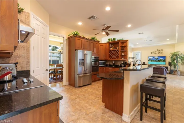 Kitchen featuring stainless steel appliances, kitchen peninsula, range hood, and ceiling fan