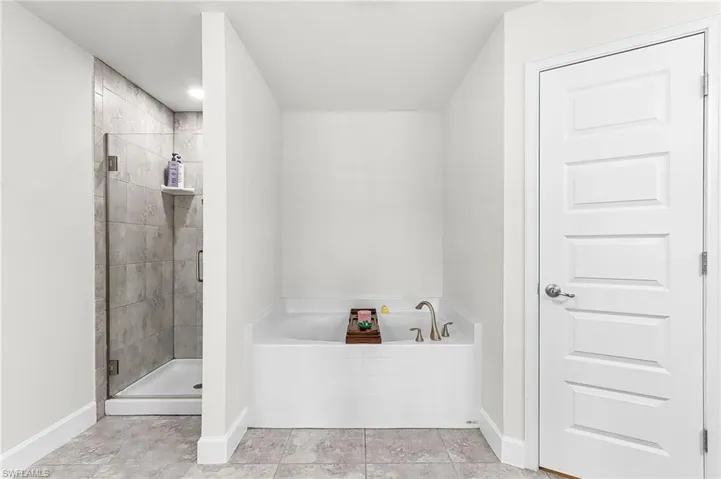 Bathroom featuring a bath and a stall shower