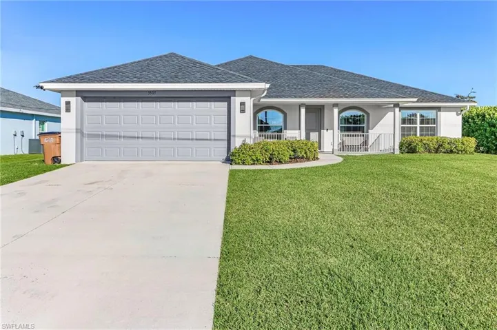 Ranch-style house with a shingled roof, stucco siding, and a front lawn