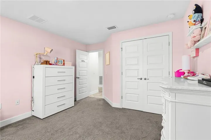 Bedroom featuring dark carpet and a closet