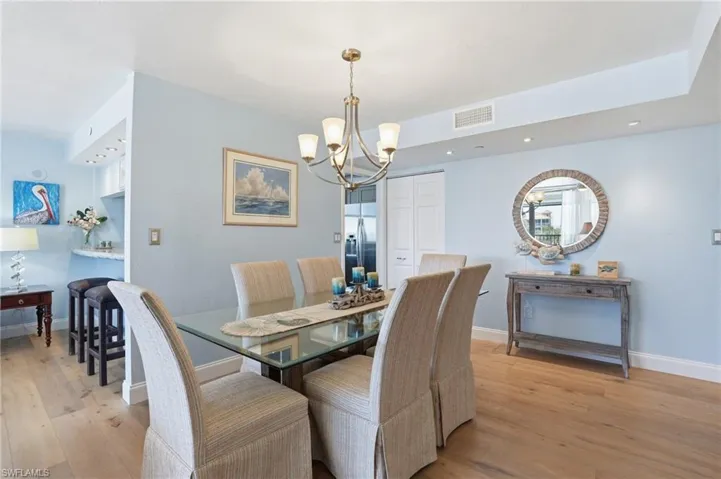Dining room featuring light wood-type flooring and suspended lighting - Virtually Edited Image