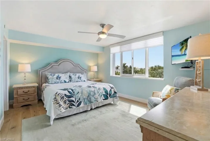 Bedroom featuring light wood finished floors and a ceiling fan - Virtually Edited Image
