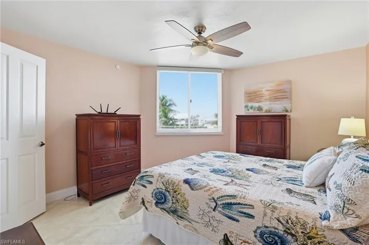 Bedroom with ceiling fan and light tile patterned floors - Virtually Edited Image