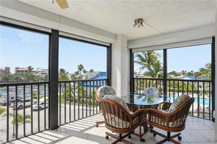 Sunroom featuring tile patterned flooring and a textured ceiling - Virtually Edited Image