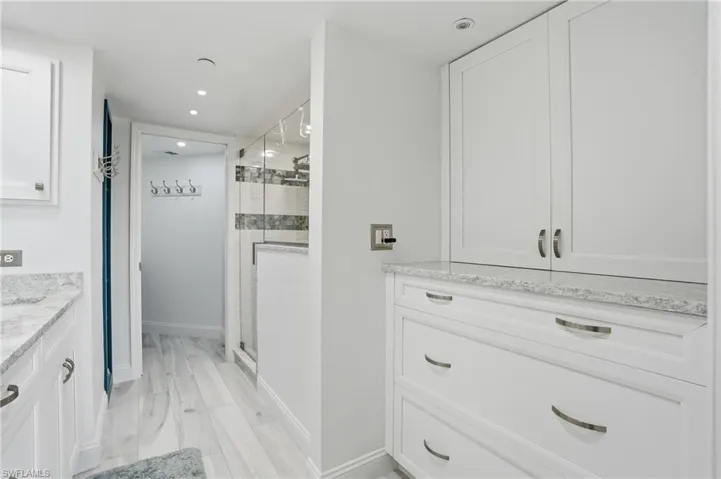 Full bathroom featuring vanity, a stall shower, recessed lighting, and light wood-type flooring - Virtually Edited Image