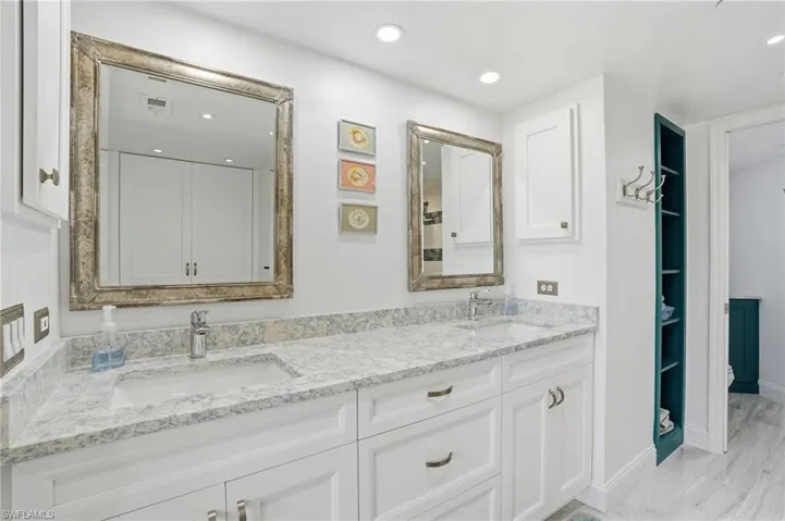 Bathroom with double vanity, recessed lighting, light marble finish flooring, and a spacious closet - Virtually Edited Image