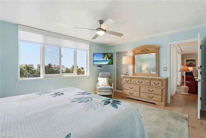 Bedroom featuring light wood-style floors and ceiling fan - Virtually Edited Image