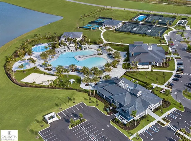 Expansive water feature with large pool, tennis courts, pickleball courts, bocce court, expansive clubhouse, on-site restaurant, a separate sport shop, and ample paved parking areas