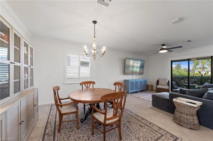 Crown molding, a decorative chandelier, and tile flooring