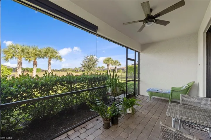 Screened lanai featuring a ceiling fan, textured wall finish, motorized privacy screens and paver flooring