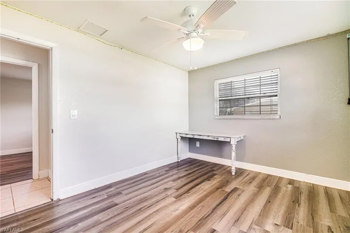 Empty room with light wood-style floors and a ceiling fan