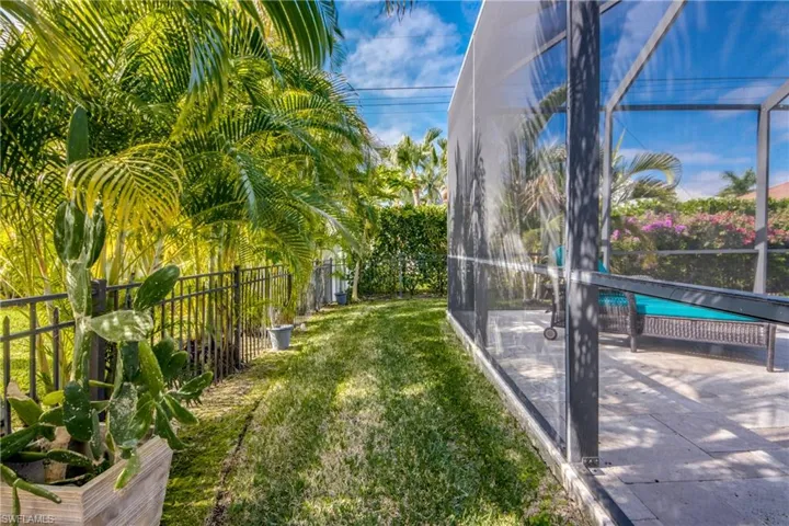 Fenced backyard with a lanai, a pool, and a sunroom