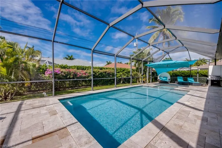 View of swimming pool with glass enclosure, a sunroom, a pool with connected hot tub, and a patio