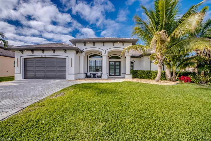 Mediterranean / spanish house featuring decorative driveway, stucco siding, an attached garage, and a front yard