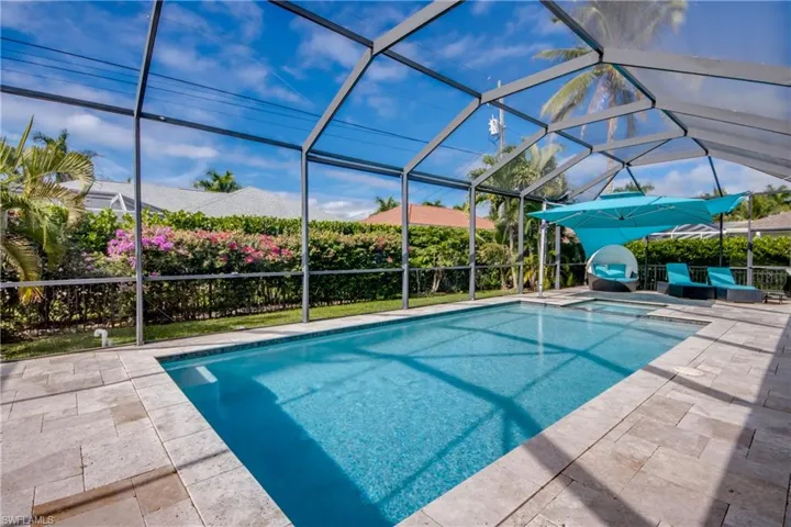 View of pool with a lanai, a pool with connected hot tub, a sunroom, and a patio area
