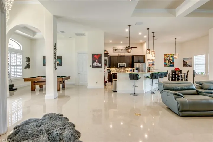 Living room featuring pool table, crown molding, arched walkways, and recessed lighting