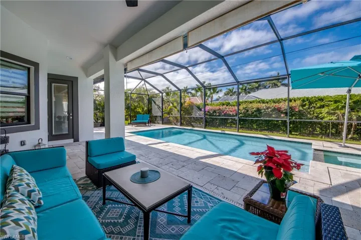 Swimming pool with a patio area, a sunroom, glass enclosure, and an outdoor living space