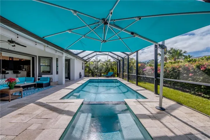 View of swimming pool featuring a sunroom, a lanai, a pool with connected hot tub, a patio area, and outdoor lounge area