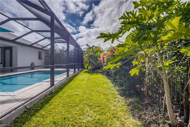 Outdoor pool featuring a lanai, a sunroom, a yard, and a patio
