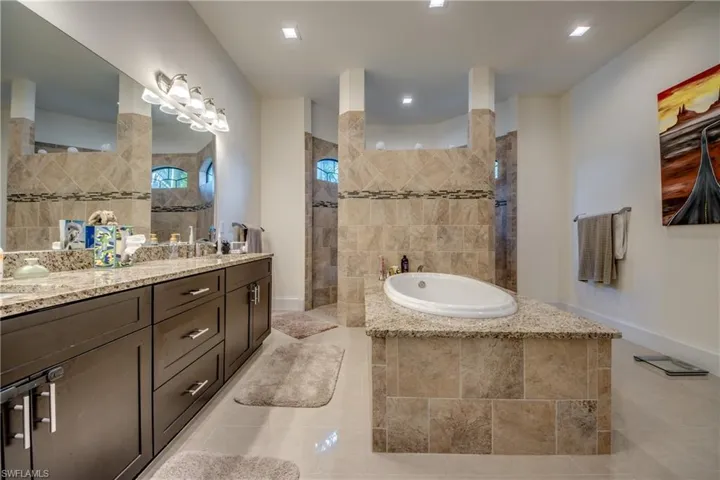 Bathroom with double vanity, a garden tub, and walk in shower