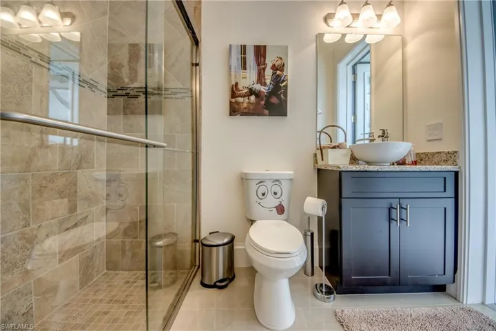 Full bath with vanity, a shower stall, and light tile patterned flooring